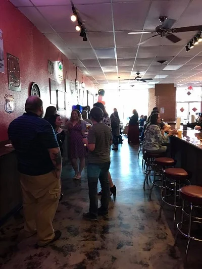 Historical tourism photograph of guests and bar seating at Growler’s Pour Haus
